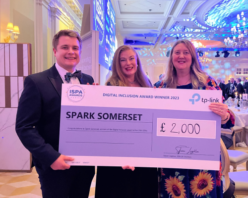 Photograph of our former Spark iT project lead being presented a large cheque at an awards ceremony