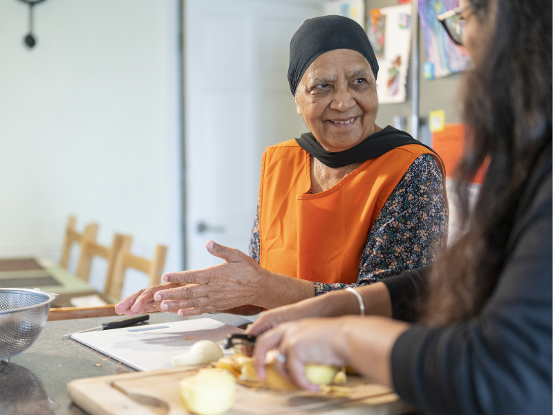 Photograph of two women preparing food at a table