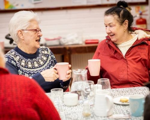 Photograph of two women sat together drinking tea