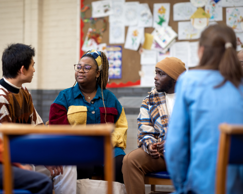 Photograph of a diverse group of people in conserversation at a table